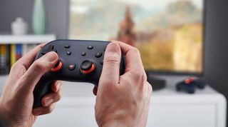 A Stadia controller being held.