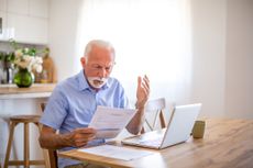 a man sitting at his table surprised by a document he's reading 
