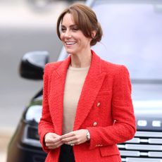 Princess Kate wearing a red blazer and smiling