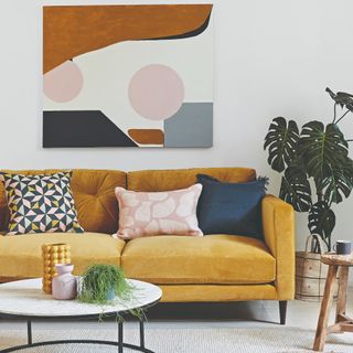Living room with a yellow sofa and and an abstract artwork