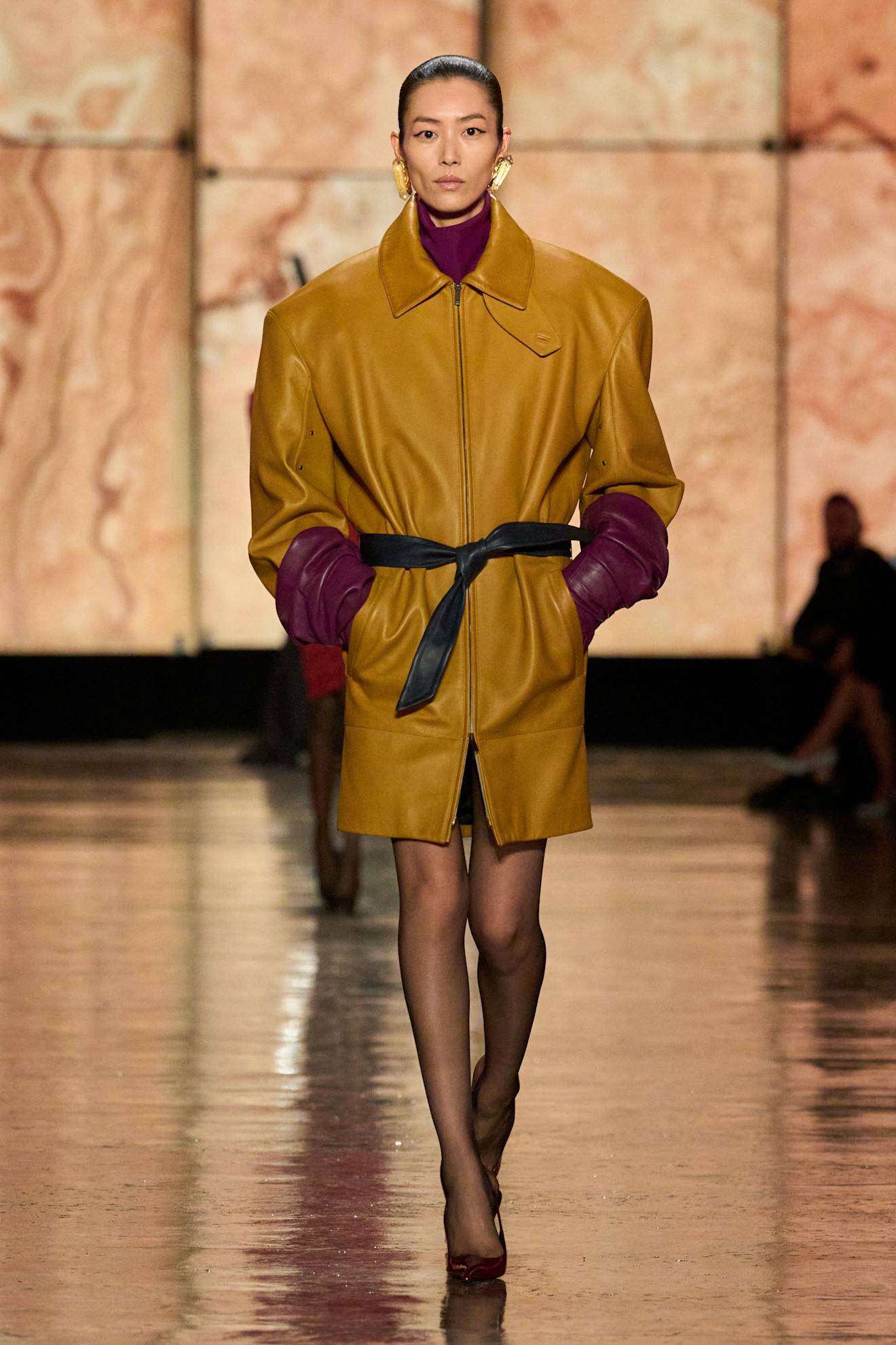 A model wears turmeric yellow on the Saint Laurent Fall 2025 runway.