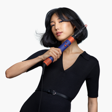 Asian model with short hair using the dyson airwrap id curling attachment 