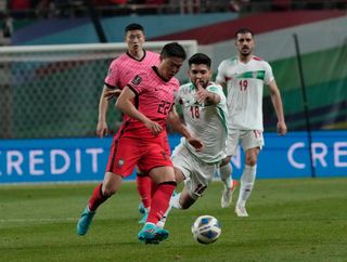 South Korea's Kwon Chang-hoon and Iran's Mahdi Mahdipour battle for the ball during a 2022 World Cup qualifying match