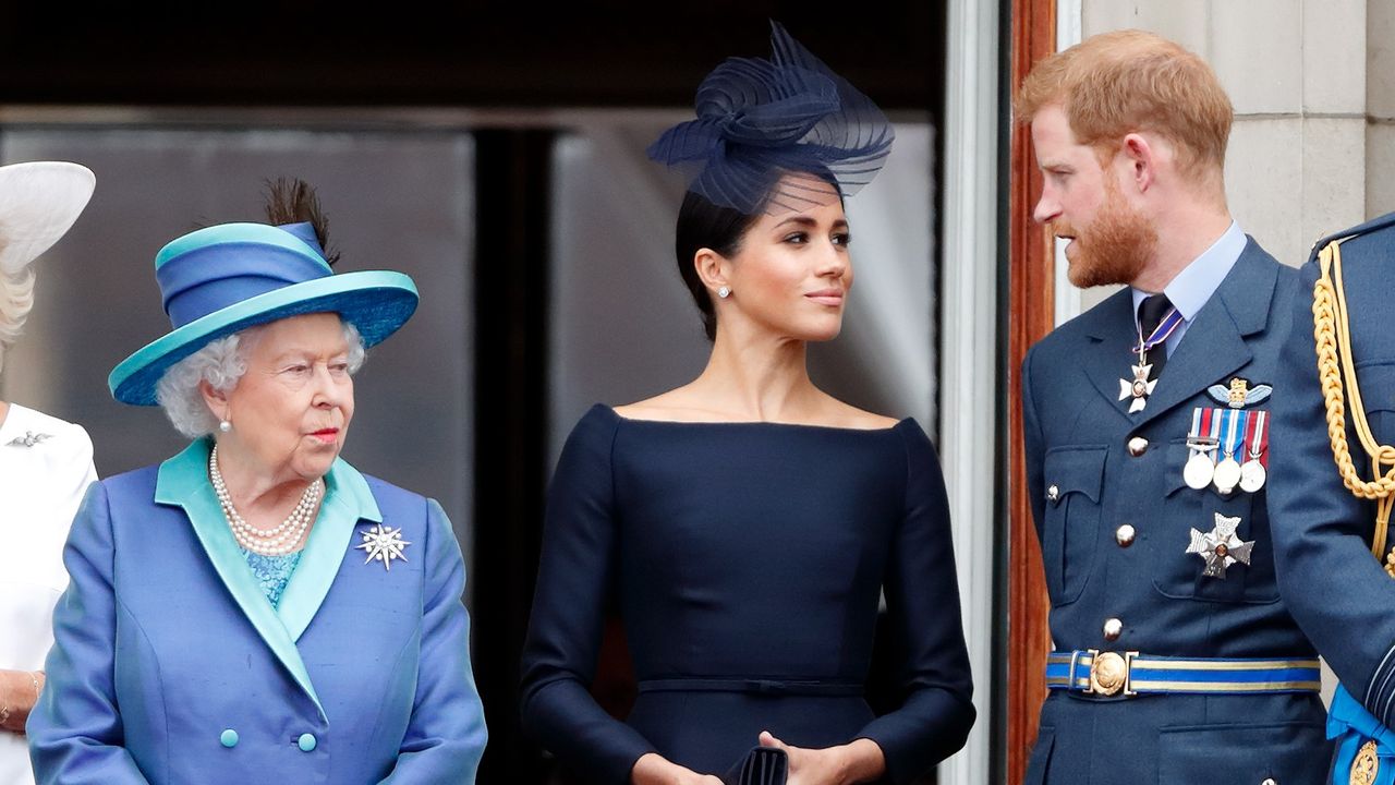 Queen Elizabeth II, Meghan, Duchess of Sussex and Prince Harry, Duke of Sussex watch a flypast to mark the centenary of the Royal Air Force from the balcony of Buckingham Palace on July 10, 2018 in London, England