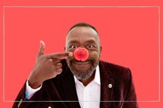 Lenny Henry wearing a red nose with a red background