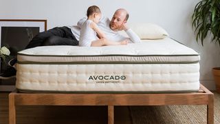 Avocado Green mattress, our best organic luxury mattress, shown here with a man and a baby sitting on top