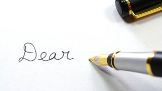 the words 'dear' on a paper with pen