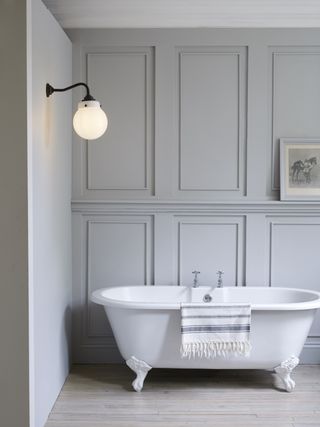 grey scheme bathroom with panels and white freestanding bath