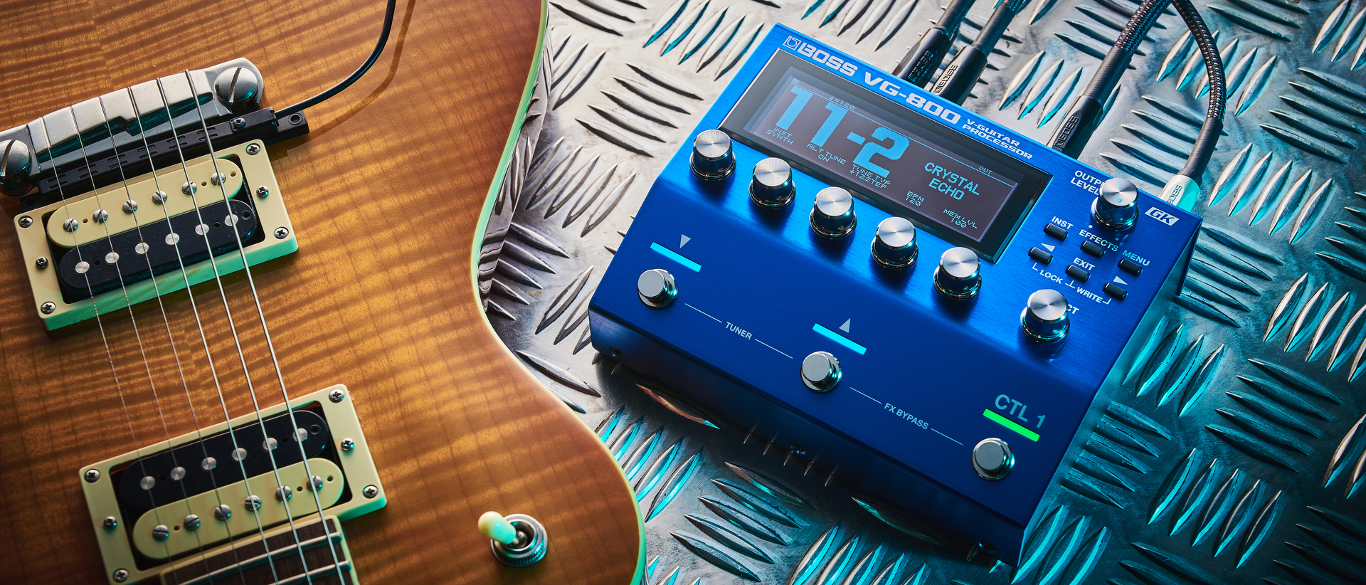 A Boss VG-800 guitar processor pedal and electric guitar lying on sheet metal
