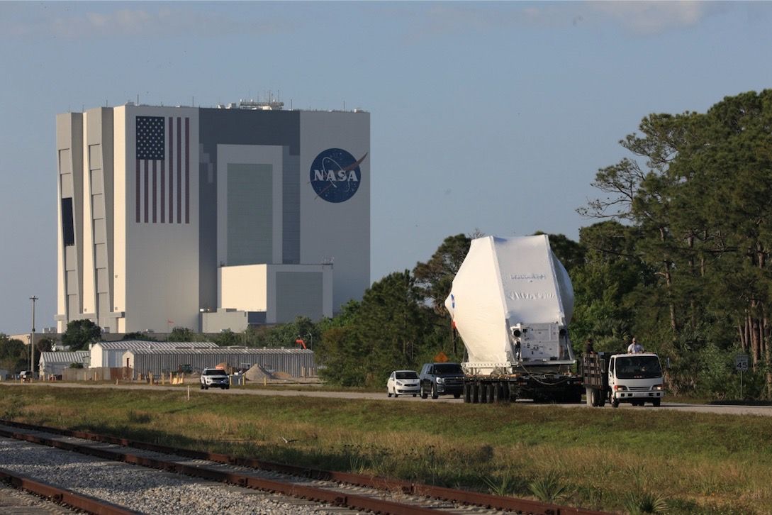 The Orion spacecraft, secured atop a transporter in its shipping container, is carried to the Neil Armstrong Operations and Checkout Building at NASA’s Kennedy Space Center in Florida on March 25, 2020. The spacecraft was transported to Kennedy in NASA’s Super Guppy aircraft from the agency’s Plum Brook Station in Ohio.