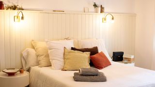 A bedroom with two light sconce fixtures above a bed