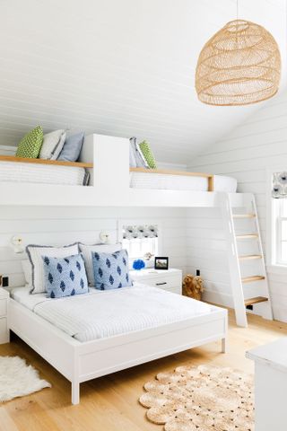 twin bunks over double bed with white walls and blue cushions rattan lampshade