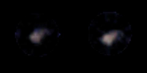 Two blurry light smears sit next to each other in a black aybss.