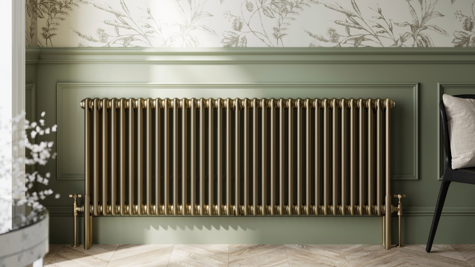 Gold radiator on a wall with half green paneling and half floral wallpaper