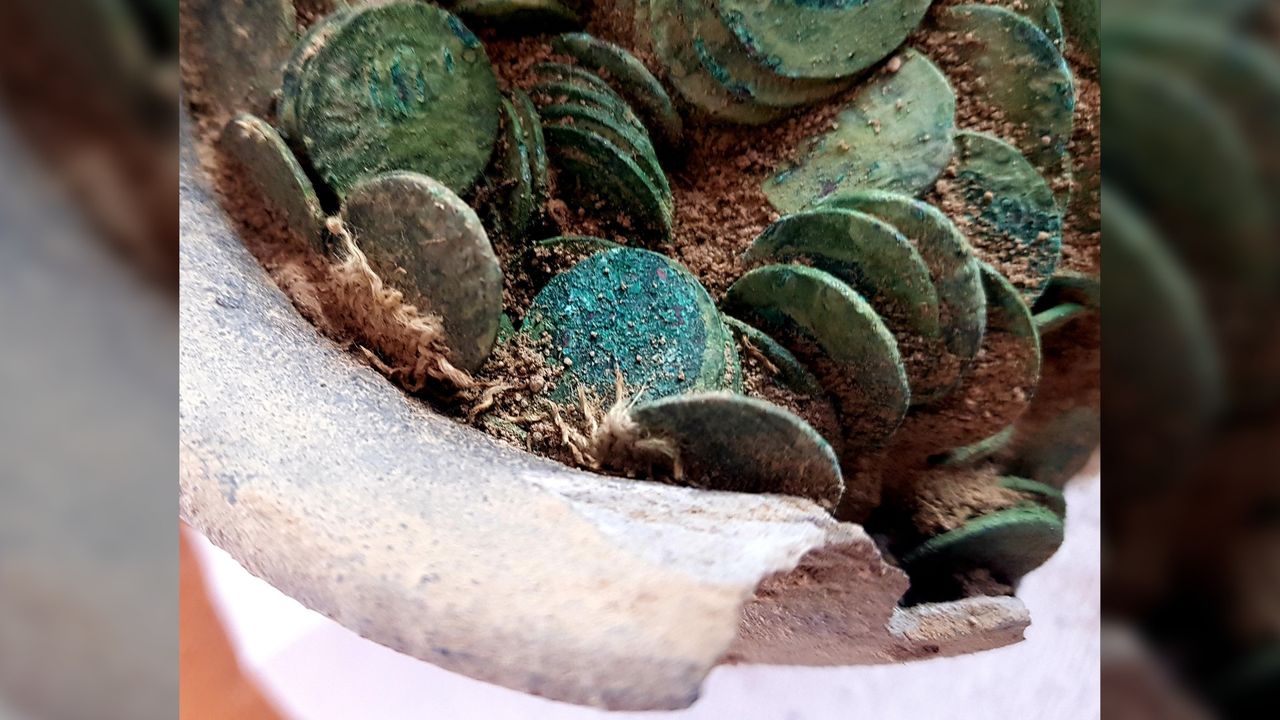 The copper coins are now green from oxidation, and many of them are corroded together in layers. The horde weighs about 6.6 pounds in total.