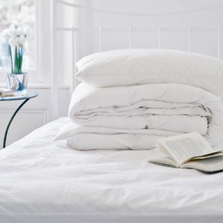 white bedsheet cushion with mattress and book
