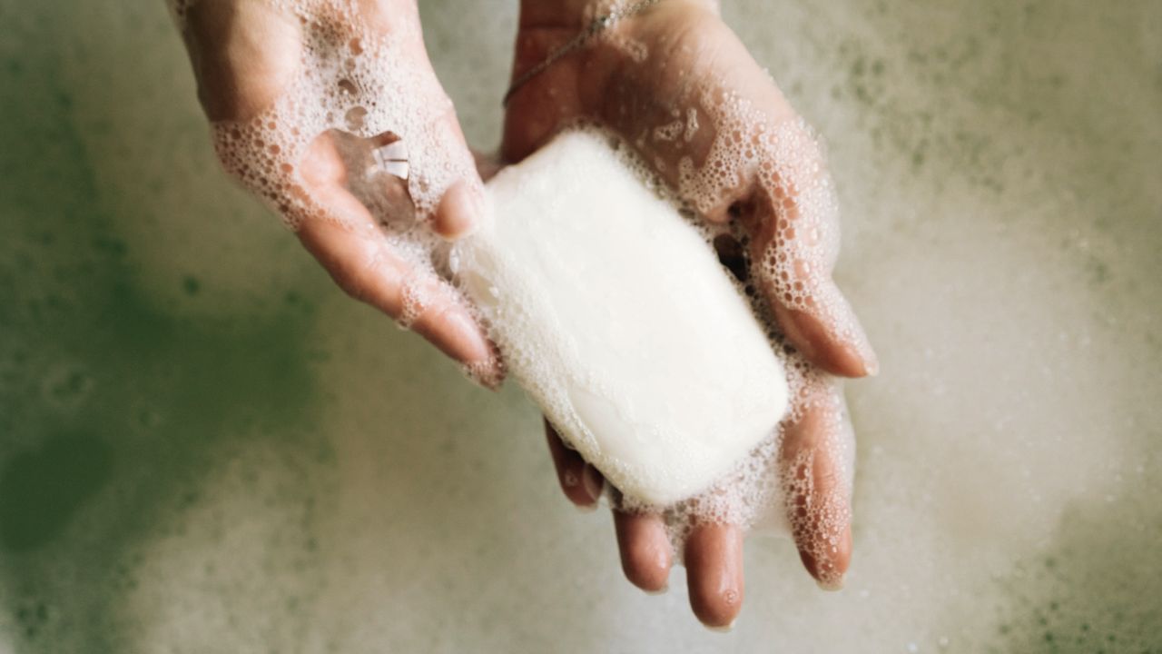 A woman washing her hands with a bar of soap