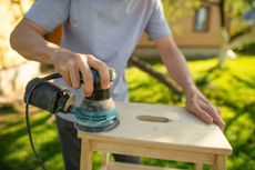 Man sanding wood with electric sander