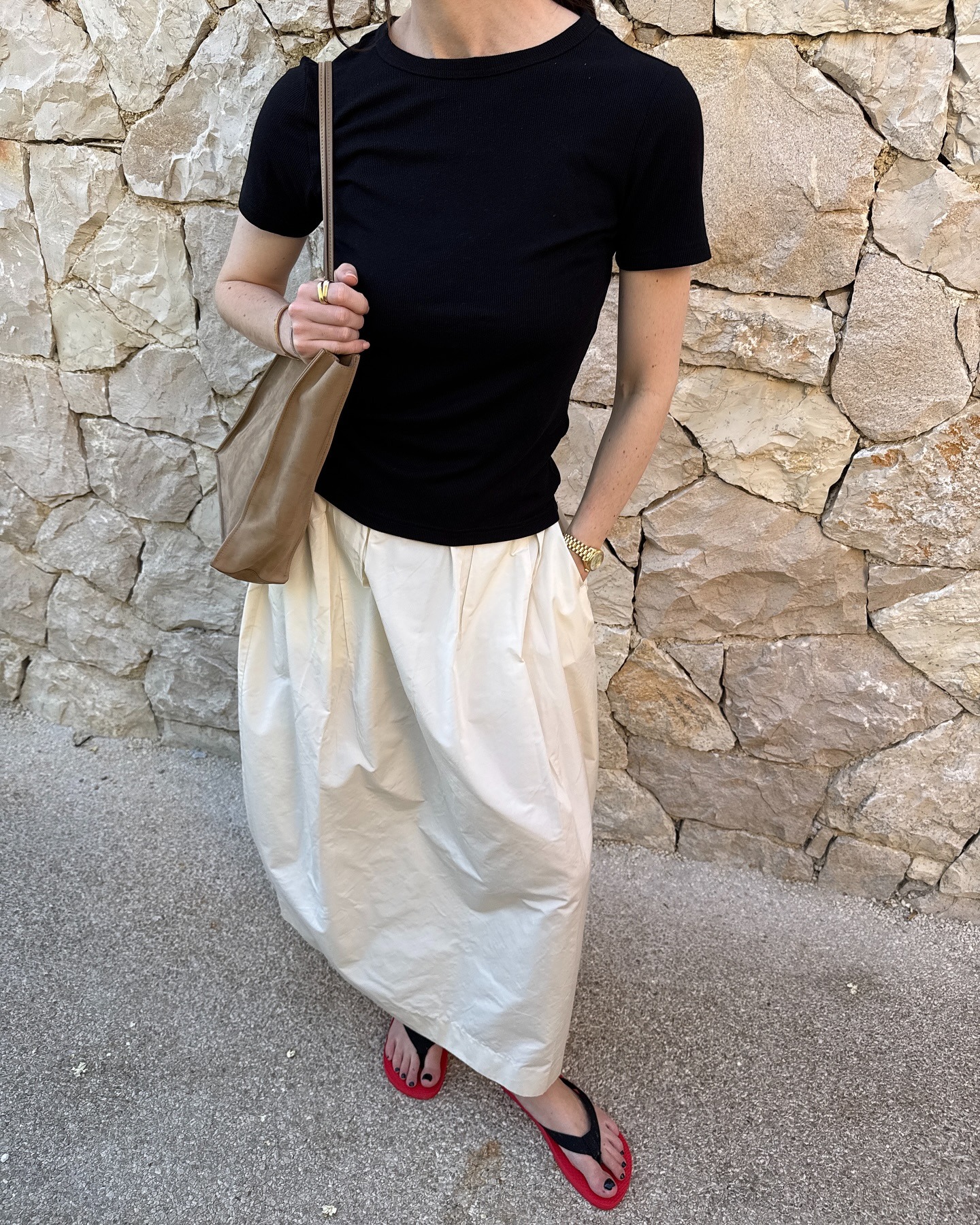 @annabelrosendahl wearing a black tee, white skirt, and two-tone thongs