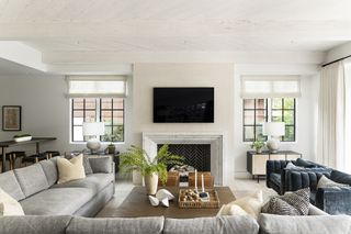 living room with large grey sectional, blue armchairs and fireplace