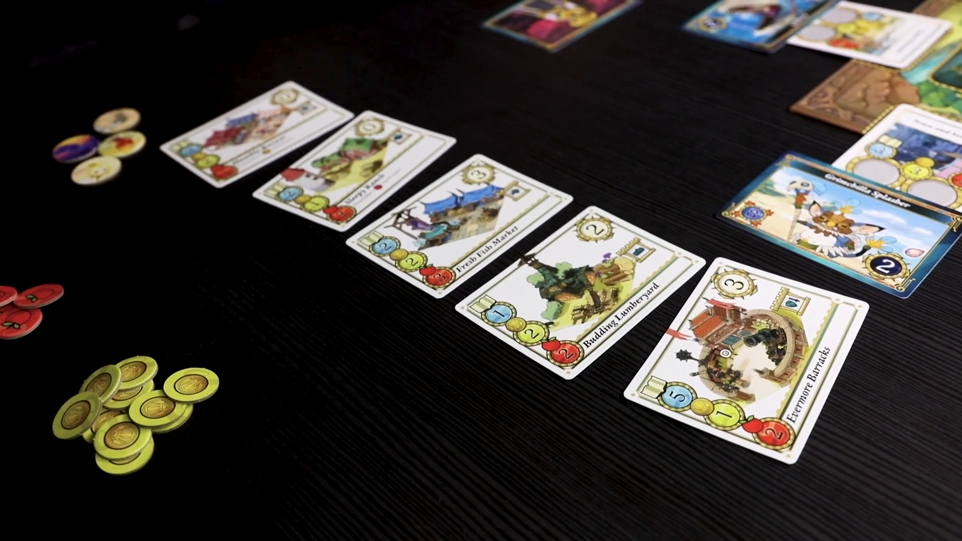 Ni No Kuni 2: The Board Game cards and components laid out on a dark surface