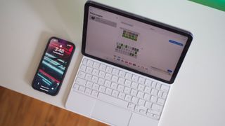 iPad Air 5 with white Magic Keyboard next to iPhone 13