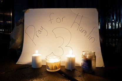 "Pray for Hamlin" sign behind candles.