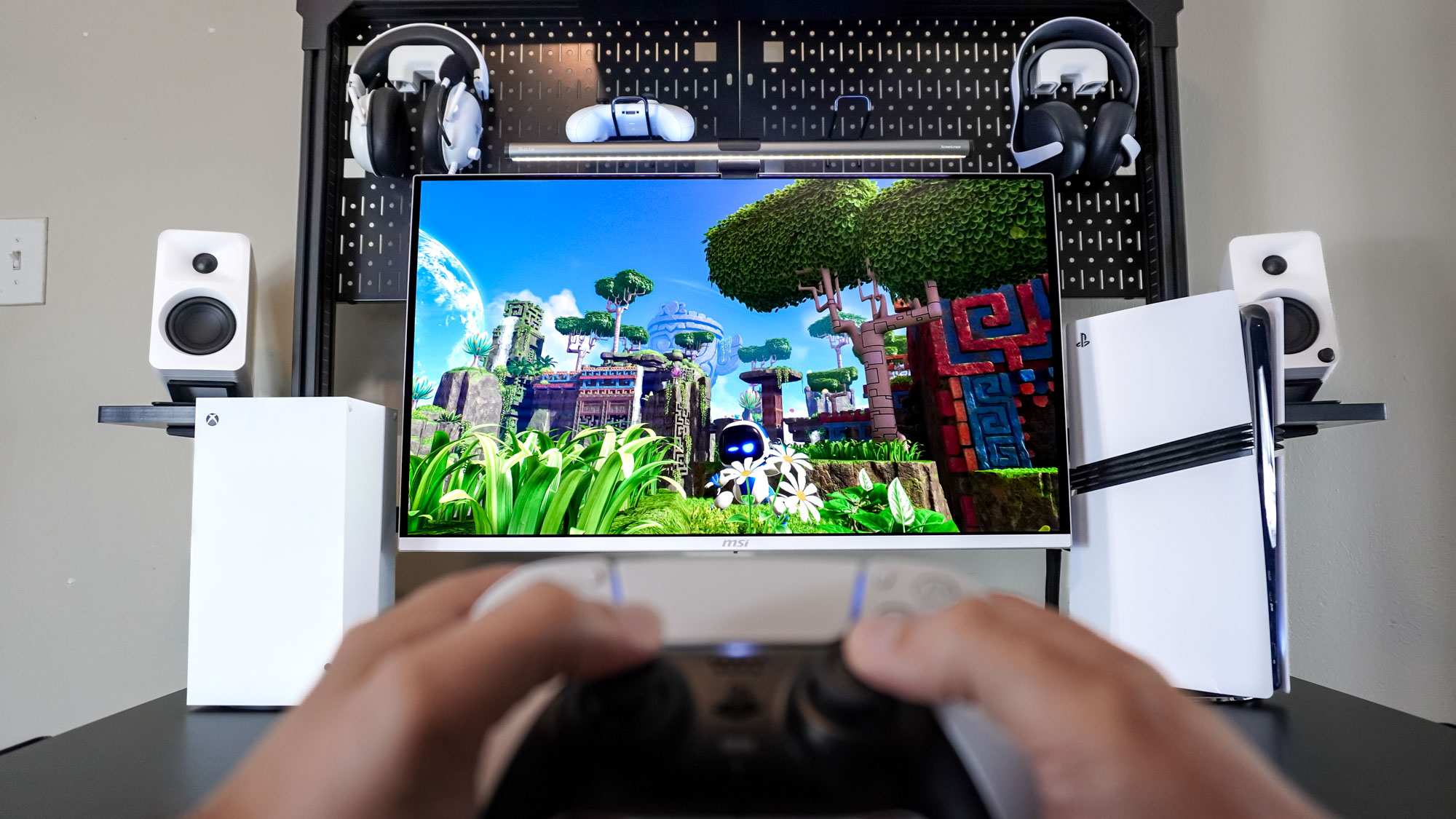 A person playing Astrobot on the PS5 Pro at a black-and-white desk setup built around the Corsair Platform:4 Elevate Desk