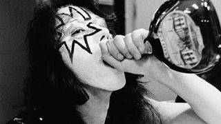 Photo of Ace FREHLEY and KISS, Ace Frehley, posed backstage during cover session for Alive! album, drinking from bottle of Mateus Rose