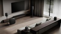 A modern living room with an LG soundbar and speakers placed around the room
