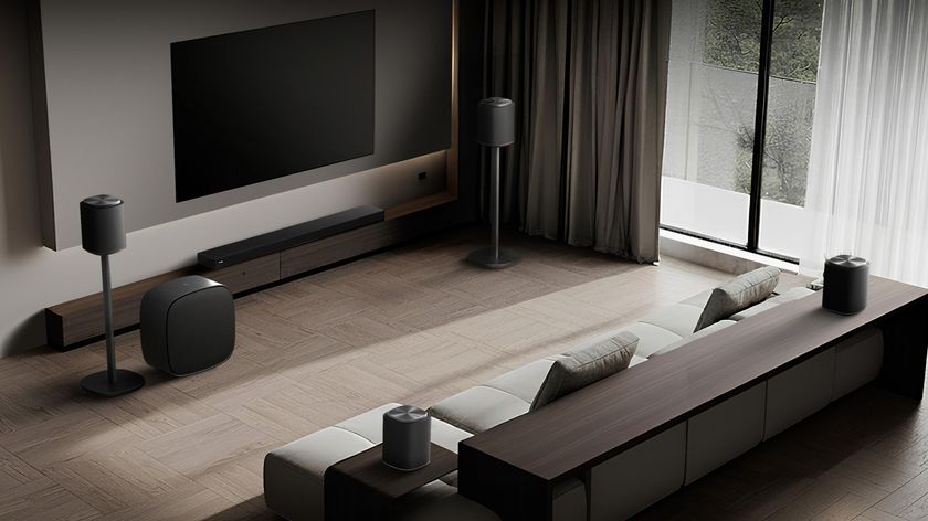 A modern living room with an LG soundbar and speakers placed around the room