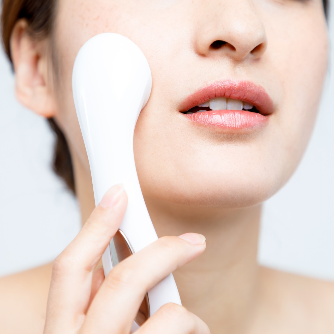 a woman using a skincare tool