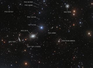 This annotated view of the surroundings of the elliptical galaxy NGC 5018 shows many of the galaxy's neighbors. The image also reveals a few asteroids that were captured by chance during the deep exposures needed to reveal the delicate streams of stars between the galaxies.