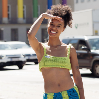 COPENHAGEN, DENMARK - AUGUST 11: Fia Hamelijnck wearing knitted green bikini top from Hope, matching blue and green knitted skirt and green shoes posing outside Helmstedt during Copenhagen Fashion Week Spring/Summer 2023 on August 11, 2022 in Copenhagen, Denmark. (Photo by Raimonda Kulikauskiene/Getty Images)