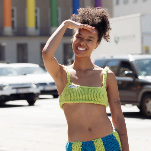 COPENHAGEN, DENMARK - AUGUST 11: Fia Hamelijnck wearing knitted green bikini top from Hope, matching blue and green knitted skirt and green shoes posing outside Helmstedt during Copenhagen Fashion Week Spring/Summer 2023 on August 11, 2022 in Copenhagen, Denmark. (Photo by Raimonda Kulikauskiene/Getty Images)