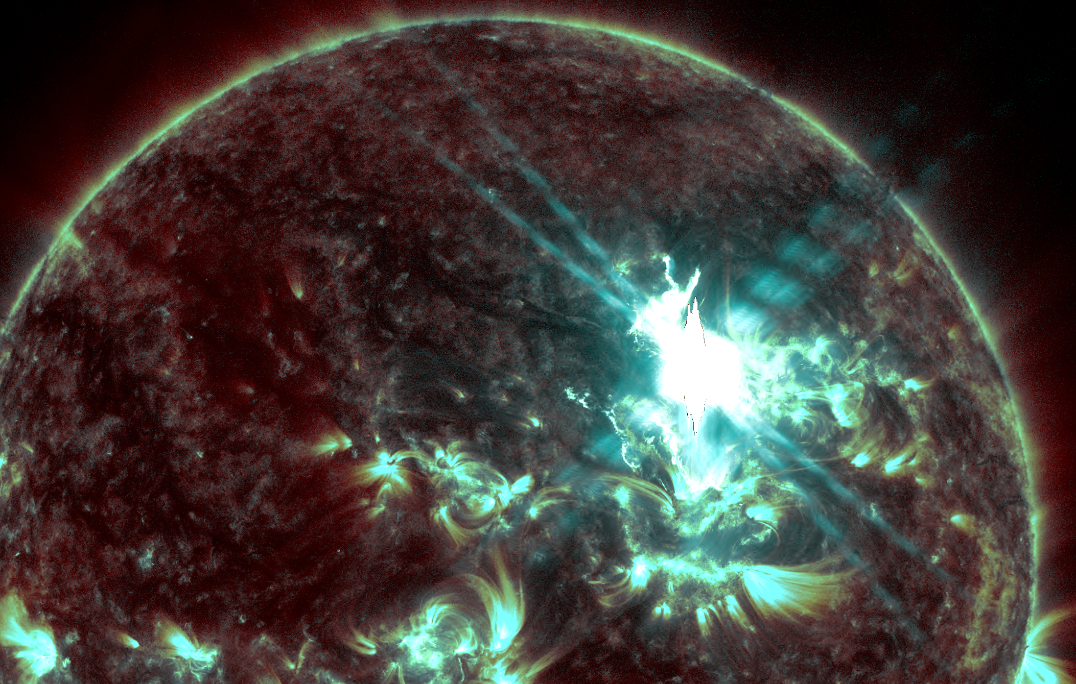 A close up of the sun's surface showing blue white light underneath a dark red surface