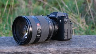 Sony a1 II camera with a Sony FE 28-70mm f/2 GM lens attached sat on a wooden bench