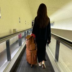 A woman carries lipault luggage in CDG airport.