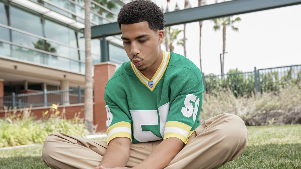 Marcus Scribner as Junior sitting outside with his legs crossed in Grown-ish season 5