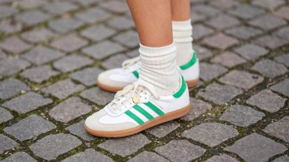COPENHAGEN, DENMARK - FEBRUARY 01: Emili Sindlev wears white socks, white shiny leather and green logo suede sneakers from Adidas , outside OperaSport , during the Copenhagen Fashion Week Autumn/Winter 2023 on February 01, 2023 in Copenhagen, Denmark. (Photo by Edward Berthelot/Getty Images)