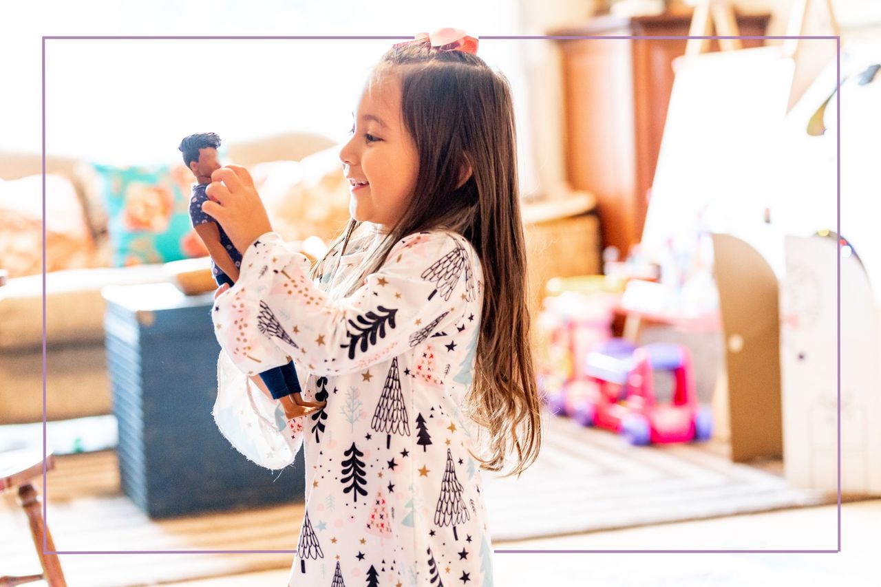 Young girl playing with Barbie dolls