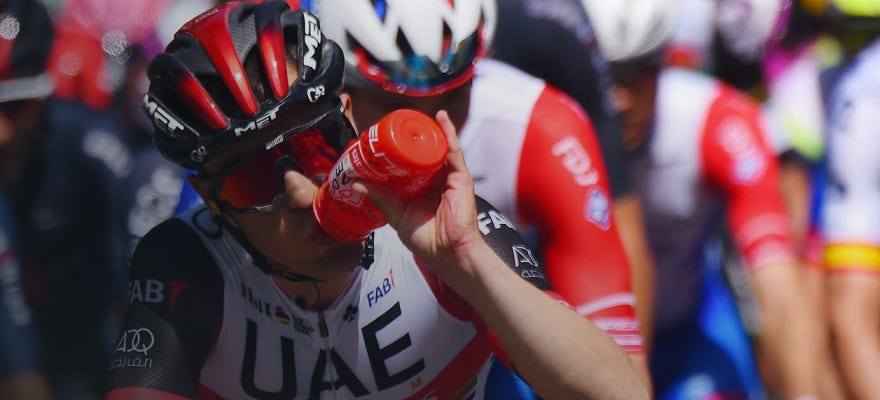 A UAE rider drinking from an Enervit bottle