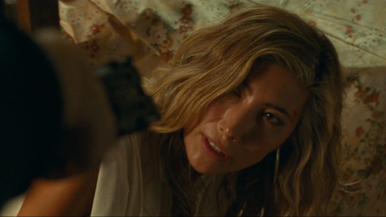 Dichen Lachman looks up at a taser being pointed at her in Jurassic World Dominion.