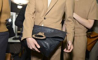 Male model holding a large clutch bag