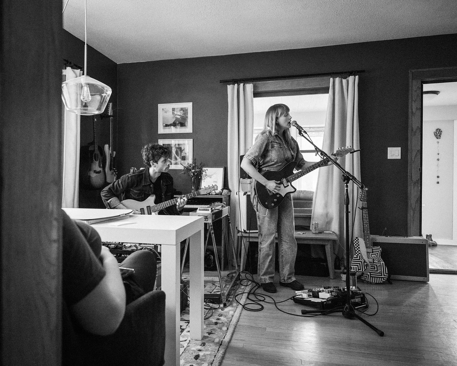 A black and white image of Jenn Wasner recording at home with her Reverend electric guitar