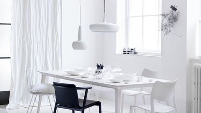 A crisp white room with one black chair