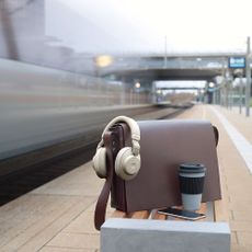 Jabra headphones resting on a satchel at a train station