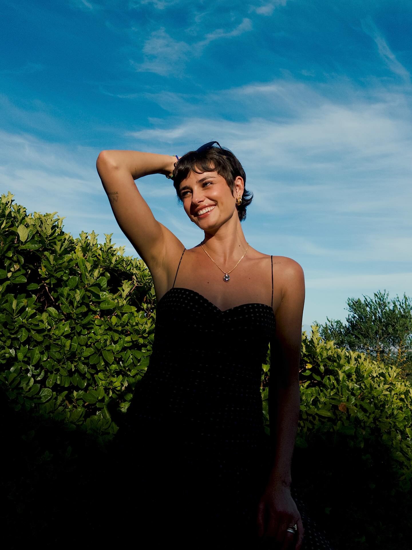 Taylor Hill wearing a summer dress with a tucked pixie hairstyle