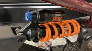 A close up of the orange coiled Fox DHX rear shock