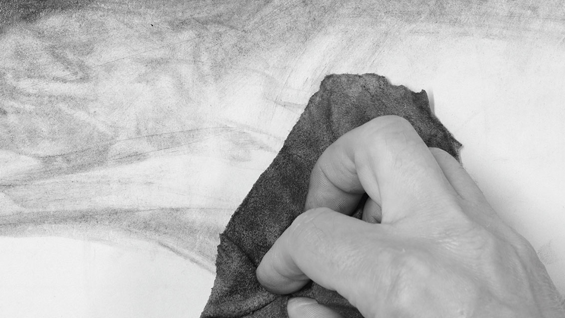 Charcoal being smudged using a chamois leather